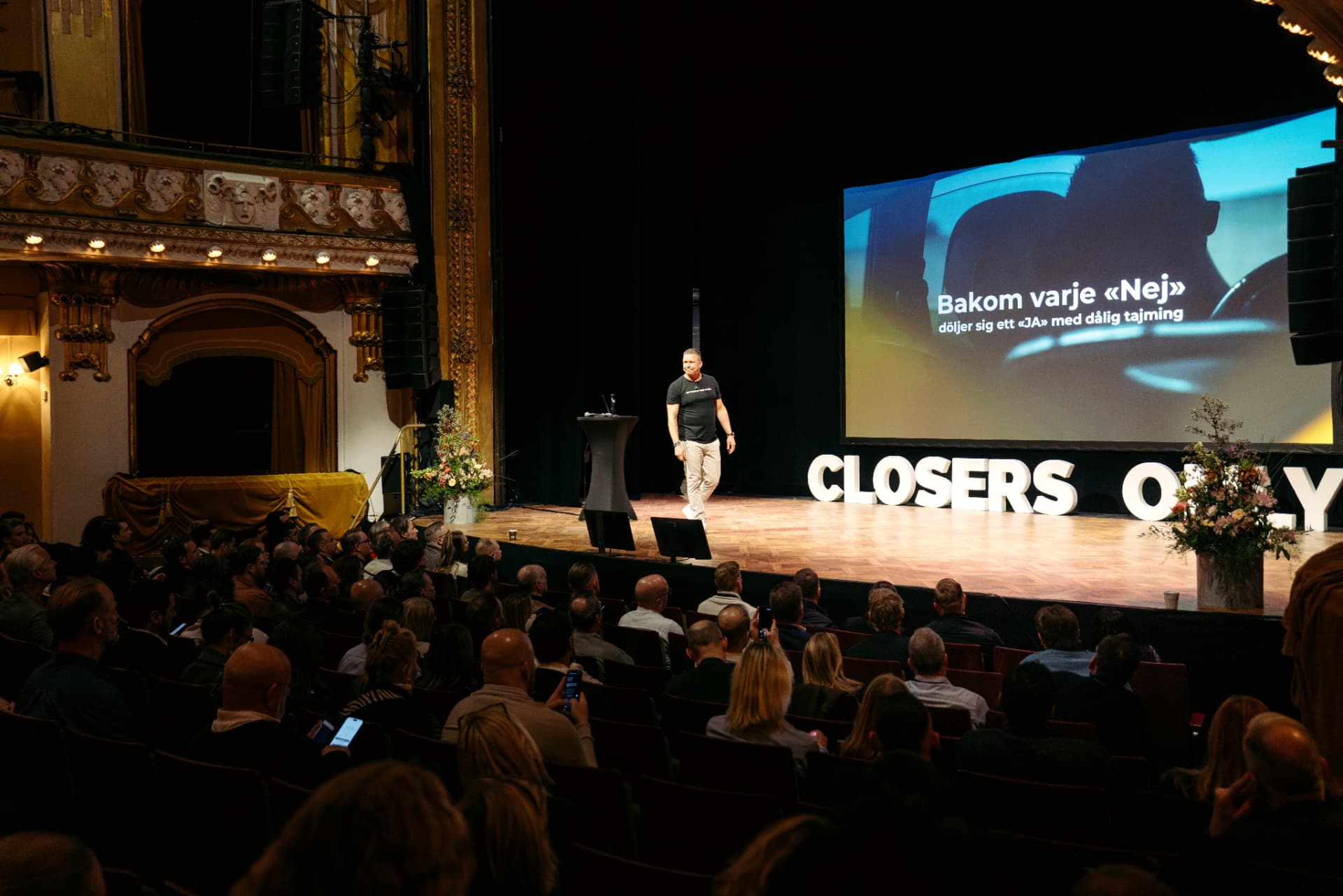 Charles Joachimsen på scenen i en fullsatt teatersal