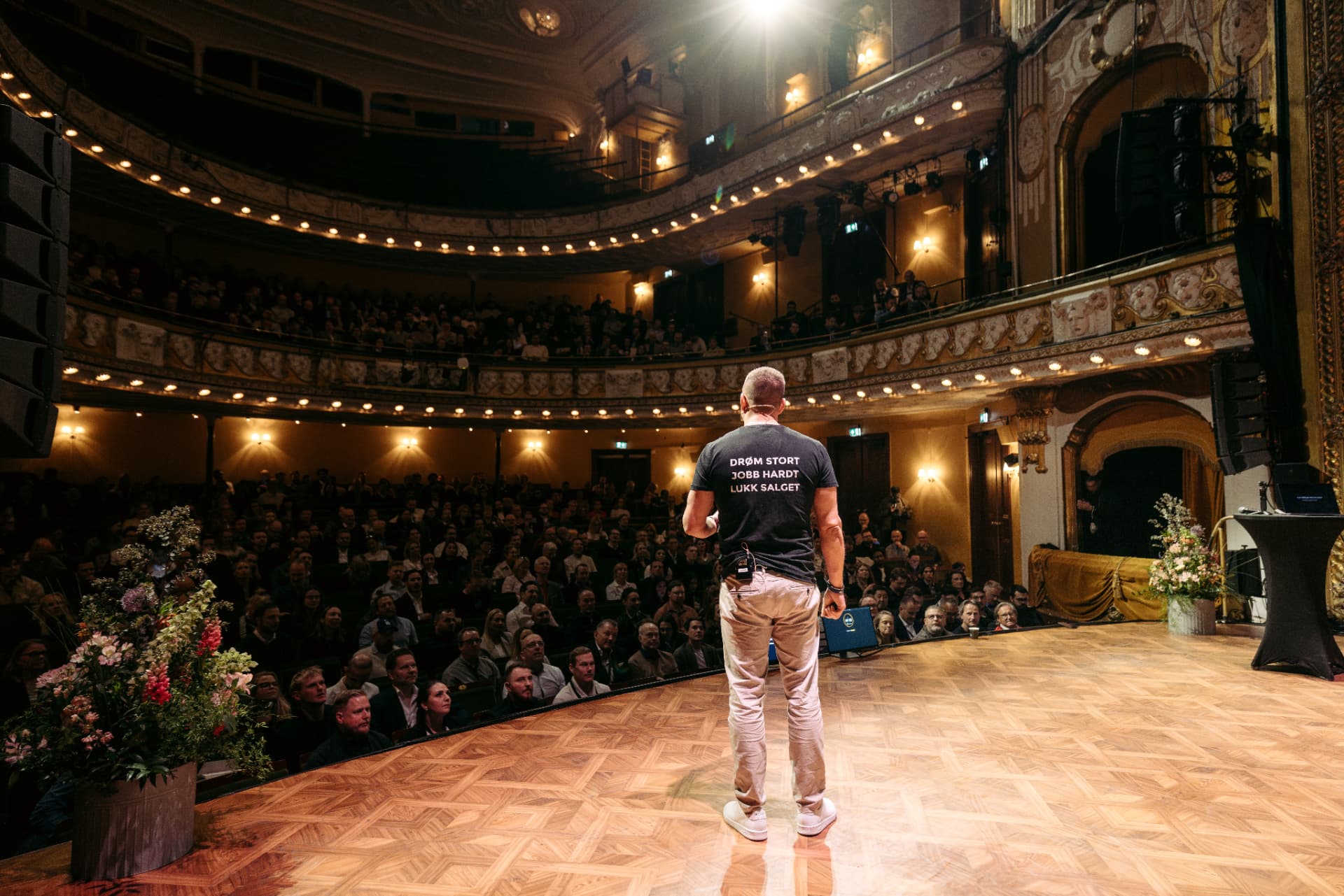 Charles Joachimsen på scenen foran en fullsatt sal