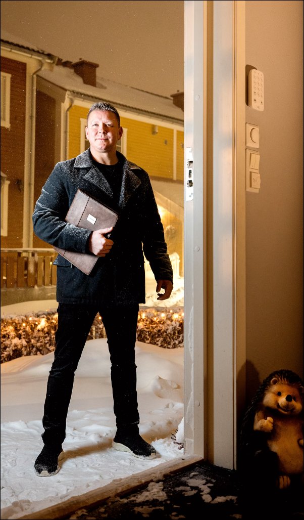 Charles Joachimsen i døråpningen på dørsalg, med mappe i hånden, vinter